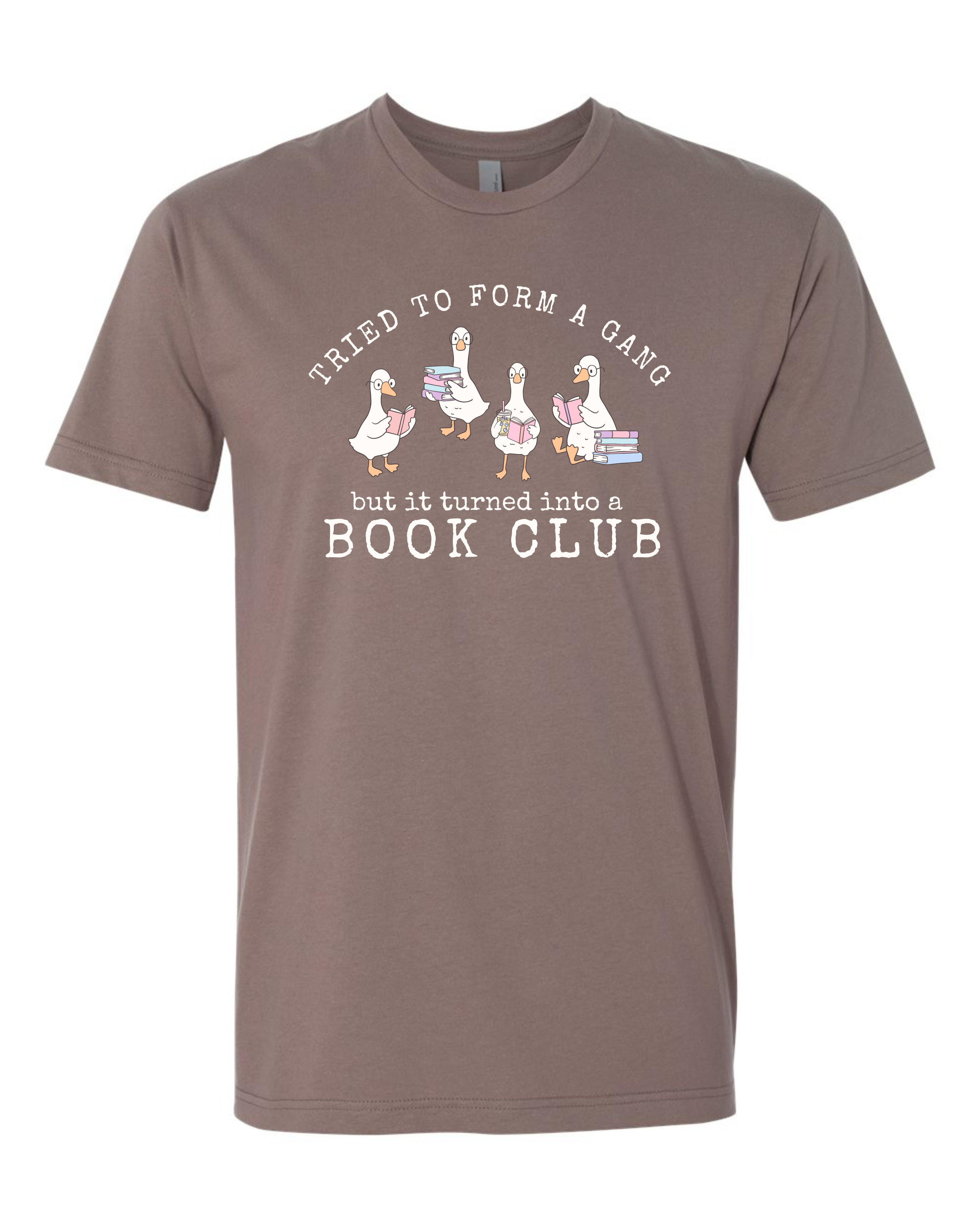 A shiitake short-sleeve crewneck t-shirt with a graphic print on the front. The graphic features four cartoon geese holding stacks of books, with the text 'Tried to form a gang but it turned into a BOOK CLUB' in white.