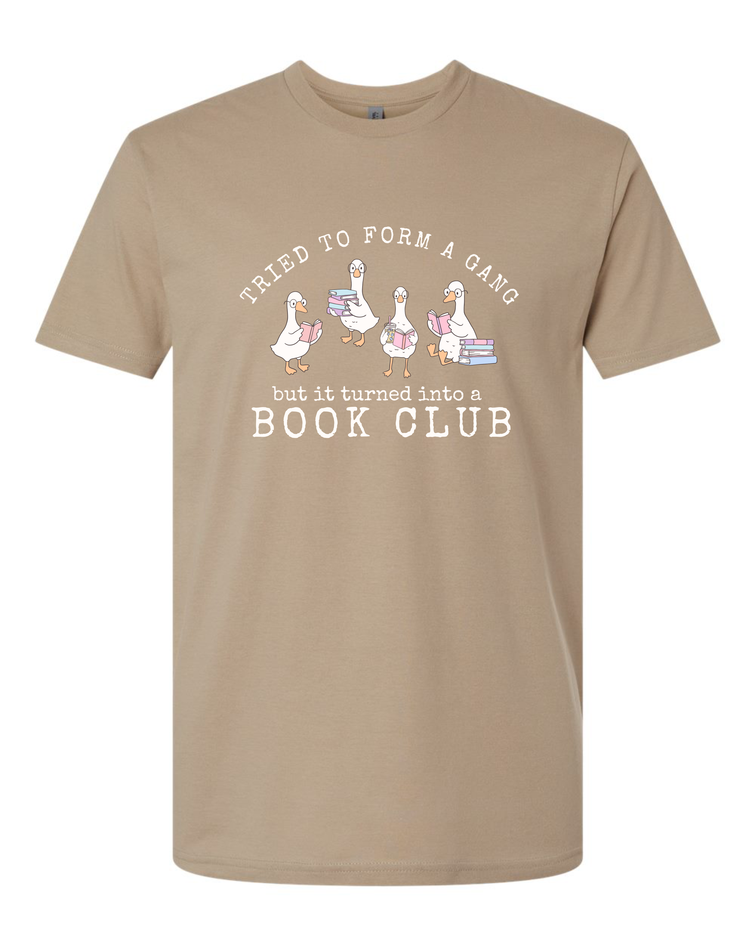 A tan short-sleeve crewneck t-shirt with a graphic print on the front. The graphic features four cartoon geese holding stacks of books, with the text 'Tried to form a gang but it turned into a BOOK CLUB' in white.